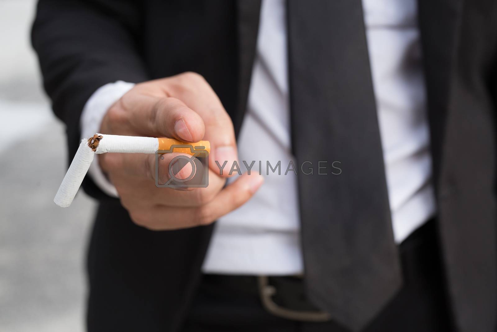 Royalty free image of businessman stand smoking Cigarettes in hand. by boytaro1428@gmail.com