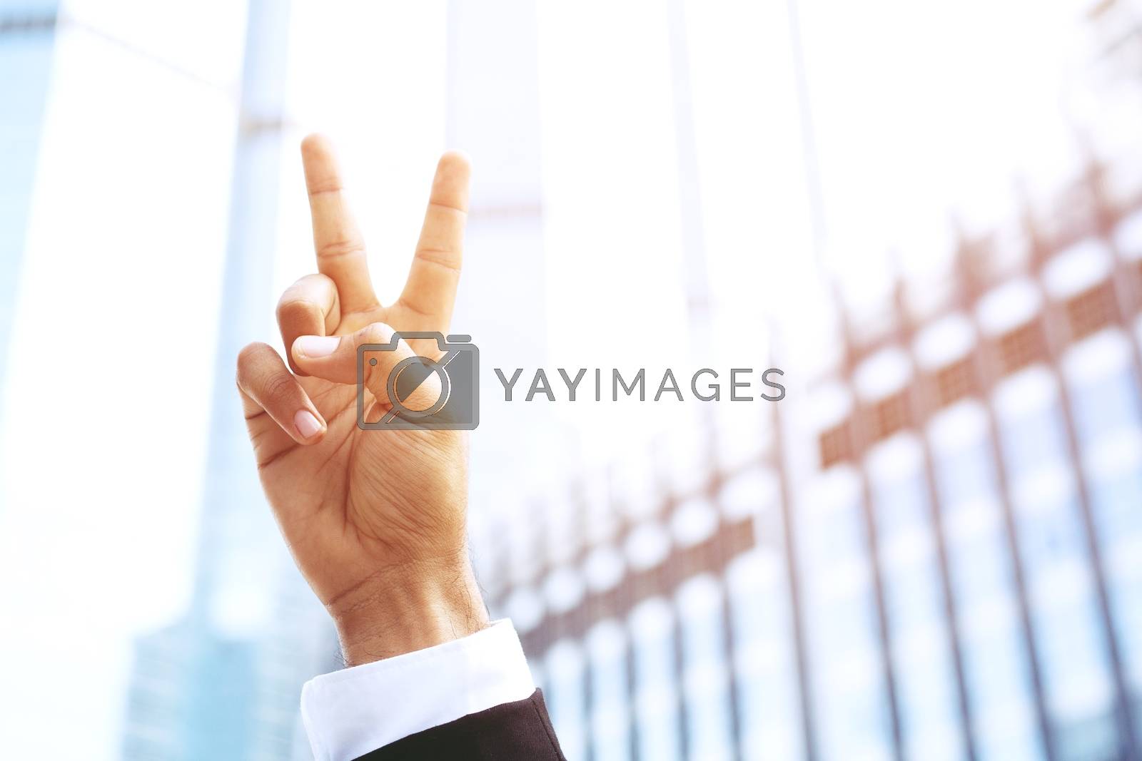Royalty free image of businessman with suit raising showing two fingers up happy cheerful. for good business. concept Success and encouragement to overcome and overcame obstacles. by boytaro1428@gmail.com