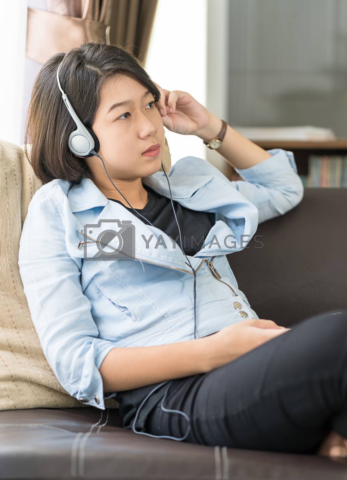 Royalty free image of Woman short hair listening music in living room by stoonn