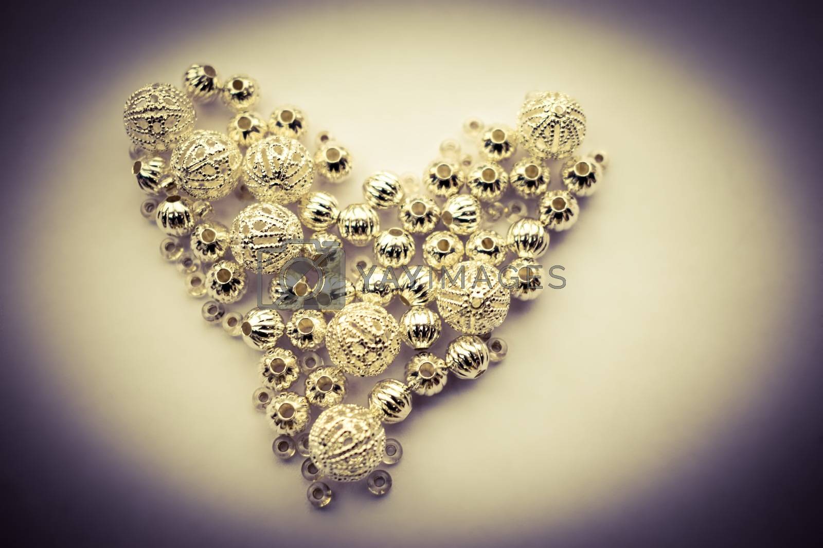 Royalty free image of selection of different silver beads shaped into a heart by sarahdavies576@gmail.com