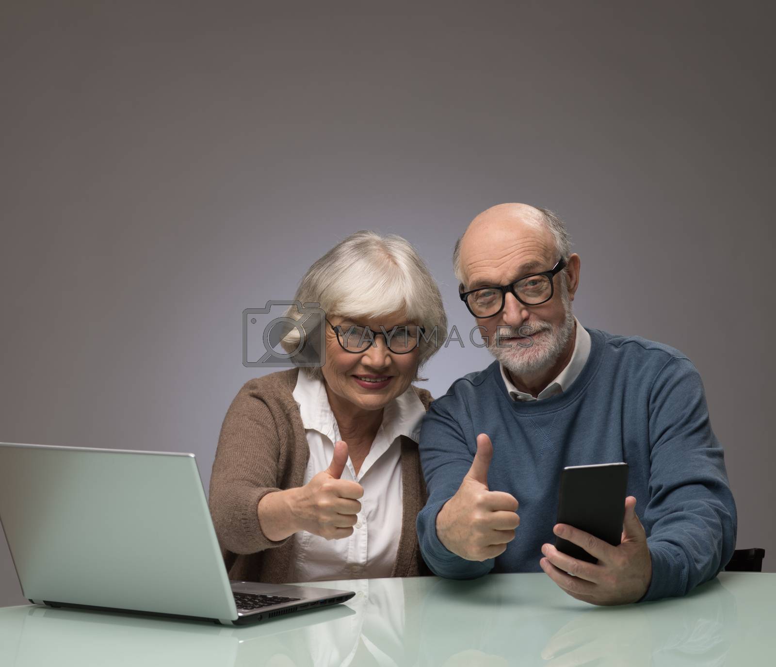Royalty free image of Senior couple with laptop and smartphone by ALotOfPeople