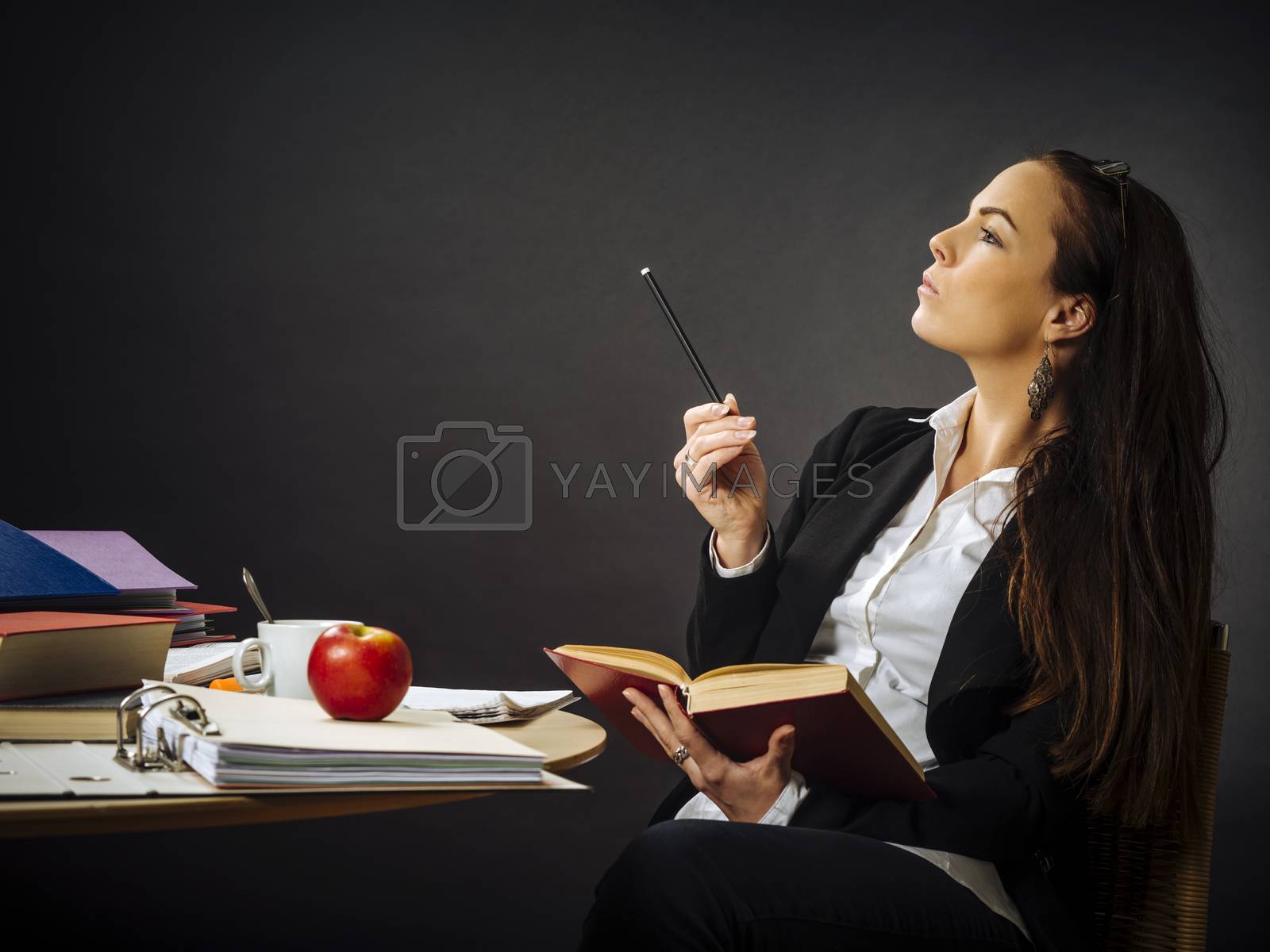 Royalty free image of Beautiful teacher sitting at her desk thinking by sumners