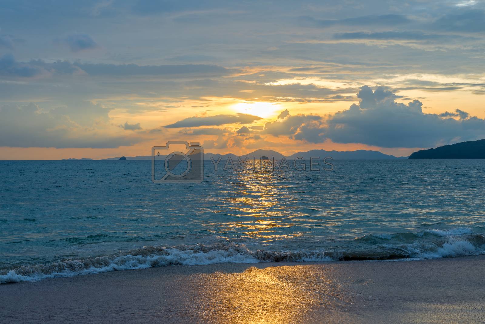 Royalty free image of clean beautiful sea in the rays of the setting sun with mountain by kosmsos111