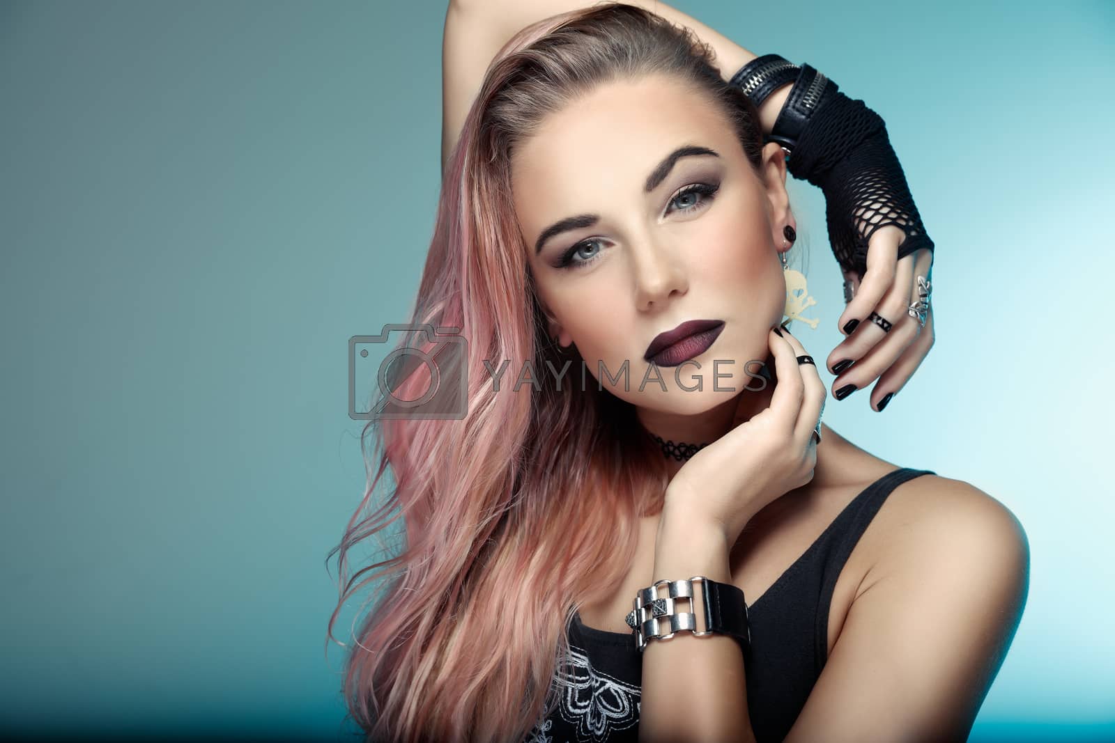 Portrait of a beautiful woman with stylish pink hair over blue background, attractive young girl with dark lips, special style makeup for Gothic party
