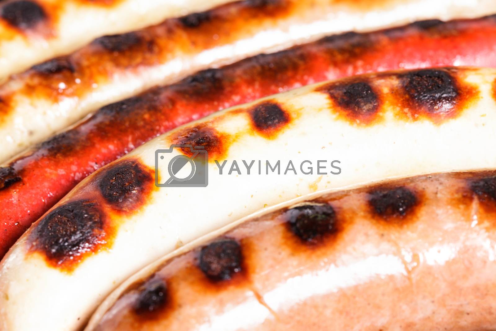Royalty free image of Closeup shot of sausages on a grill by Nobilior