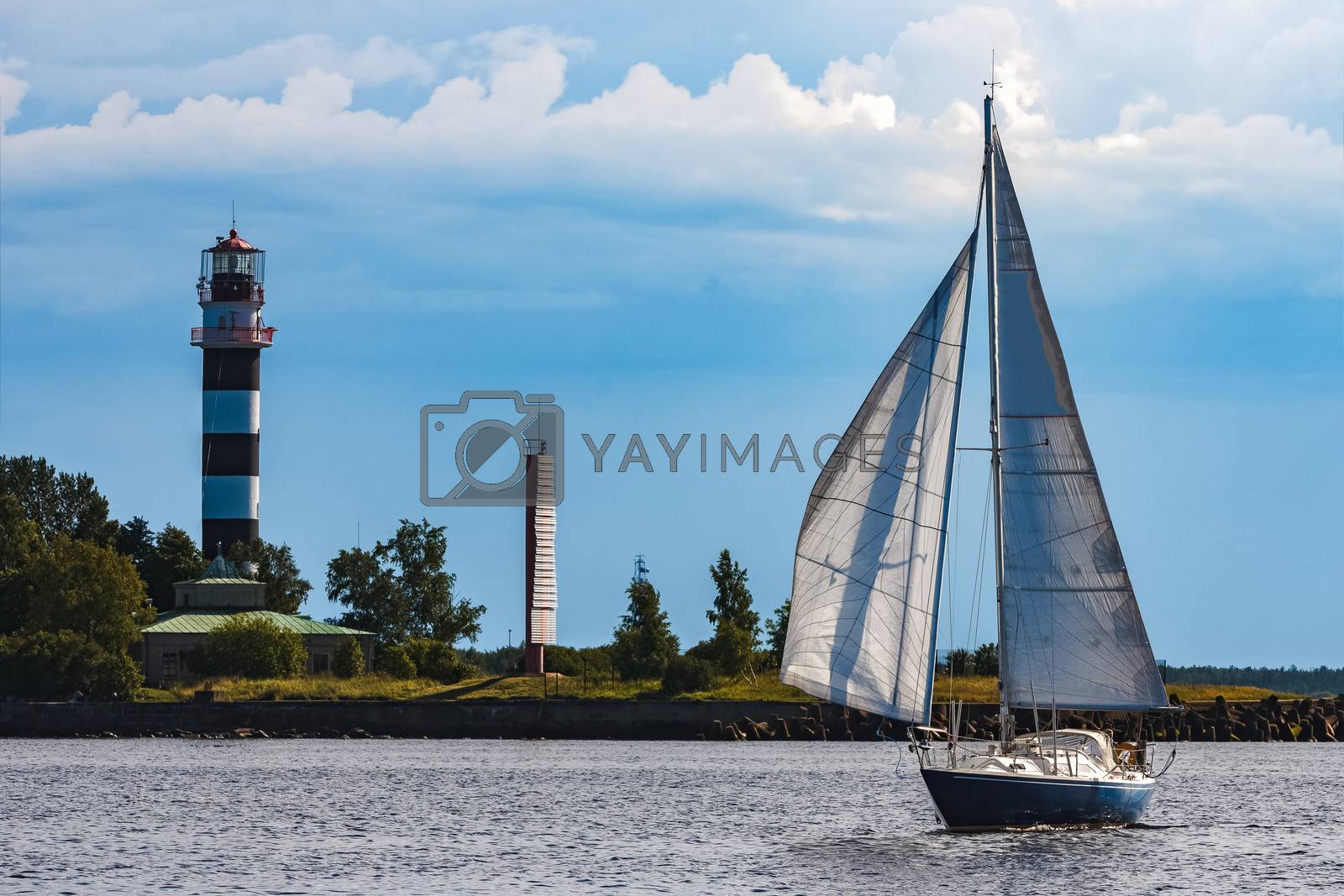 Royalty free image of Blue sailboat at river by sengnsp