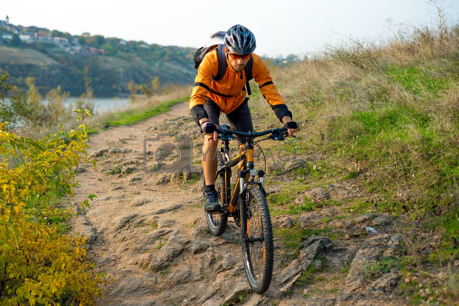 Royalty free image of Cyclist in Orange Riding the Mountain Bike on the Autumn Rocky Trail. Extreme Sport and Enduro Biking Concept. by maxpro