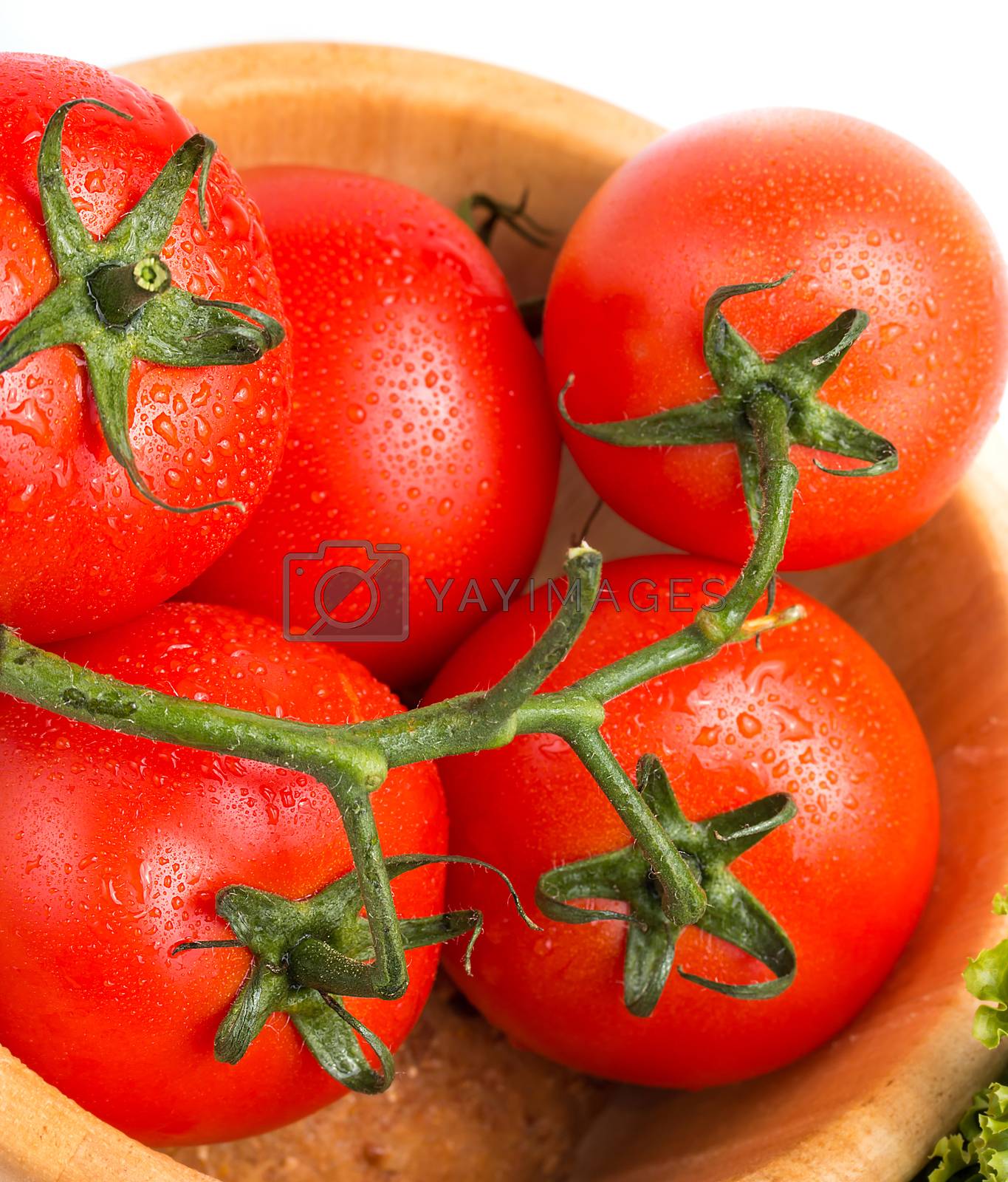Fresh red vine tomatoes in a wood bowl on the table