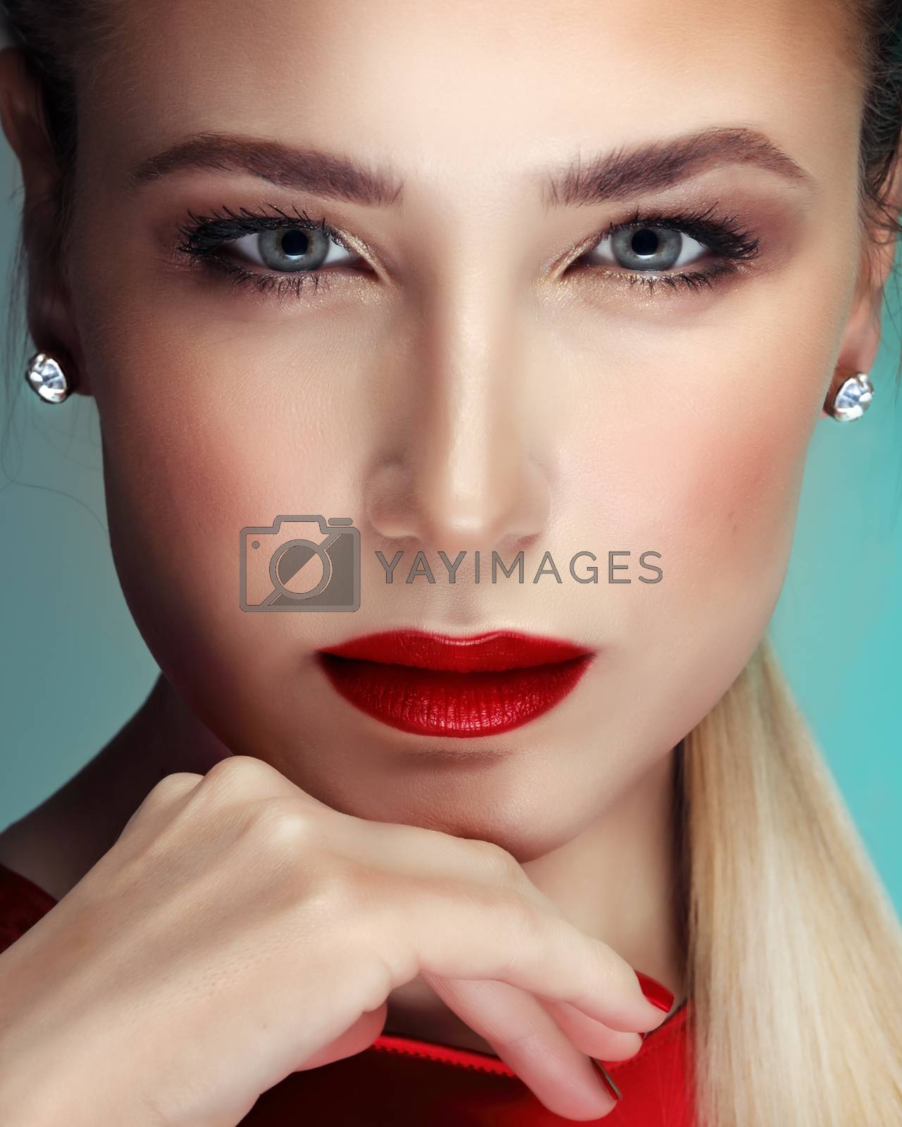Closeup portrait of a beautiful blond woman with classic evening makeup, attractive model with red lips and red nail polish, perfect professional face makeover
