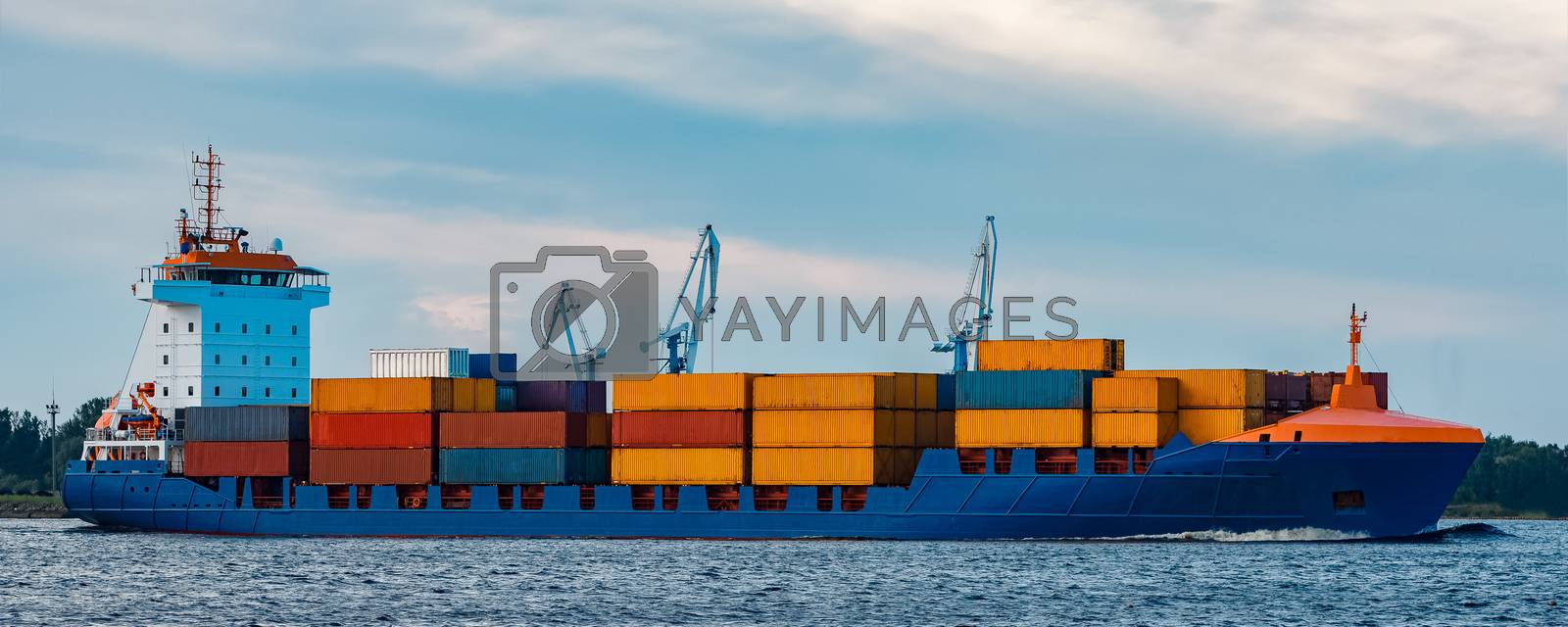 Royalty free image of Blue container ship underway by sengnsp