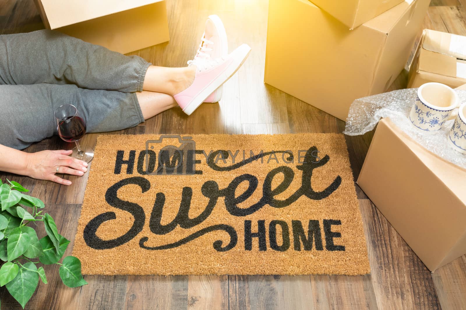 Royalty free image of Woman Wearing Sweats Relaxing Near Home Sweet Home Welcome Mat,  by Feverpitched