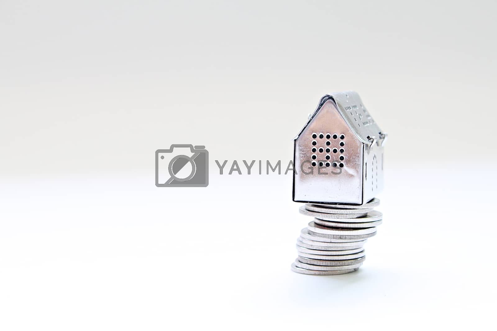 Royalty free image of House model standing on coins stack by sureeporn