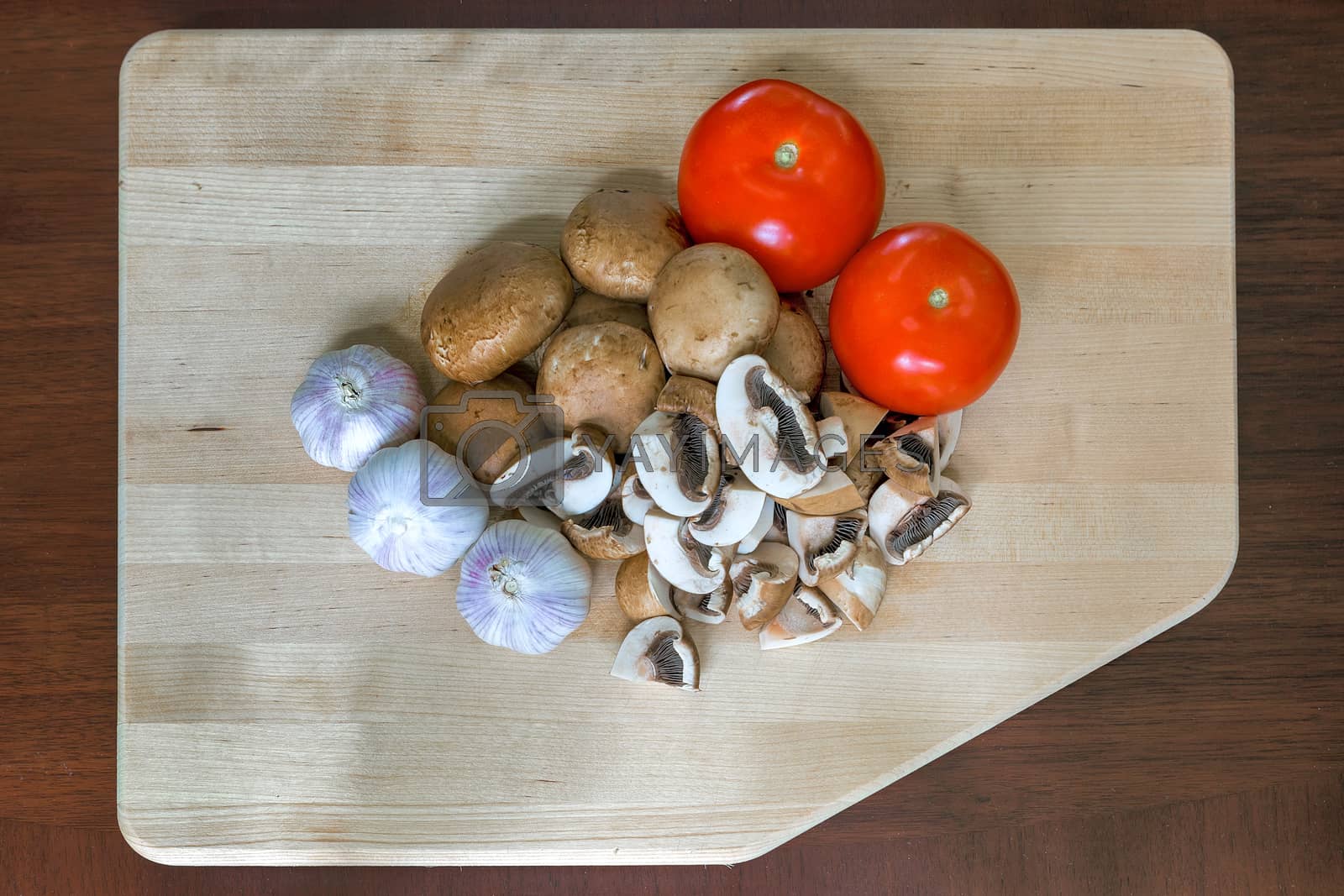 Royalty free image of Tomatoes Garlic and Portobello Mushroom on Cutting Board by jpldesigns
