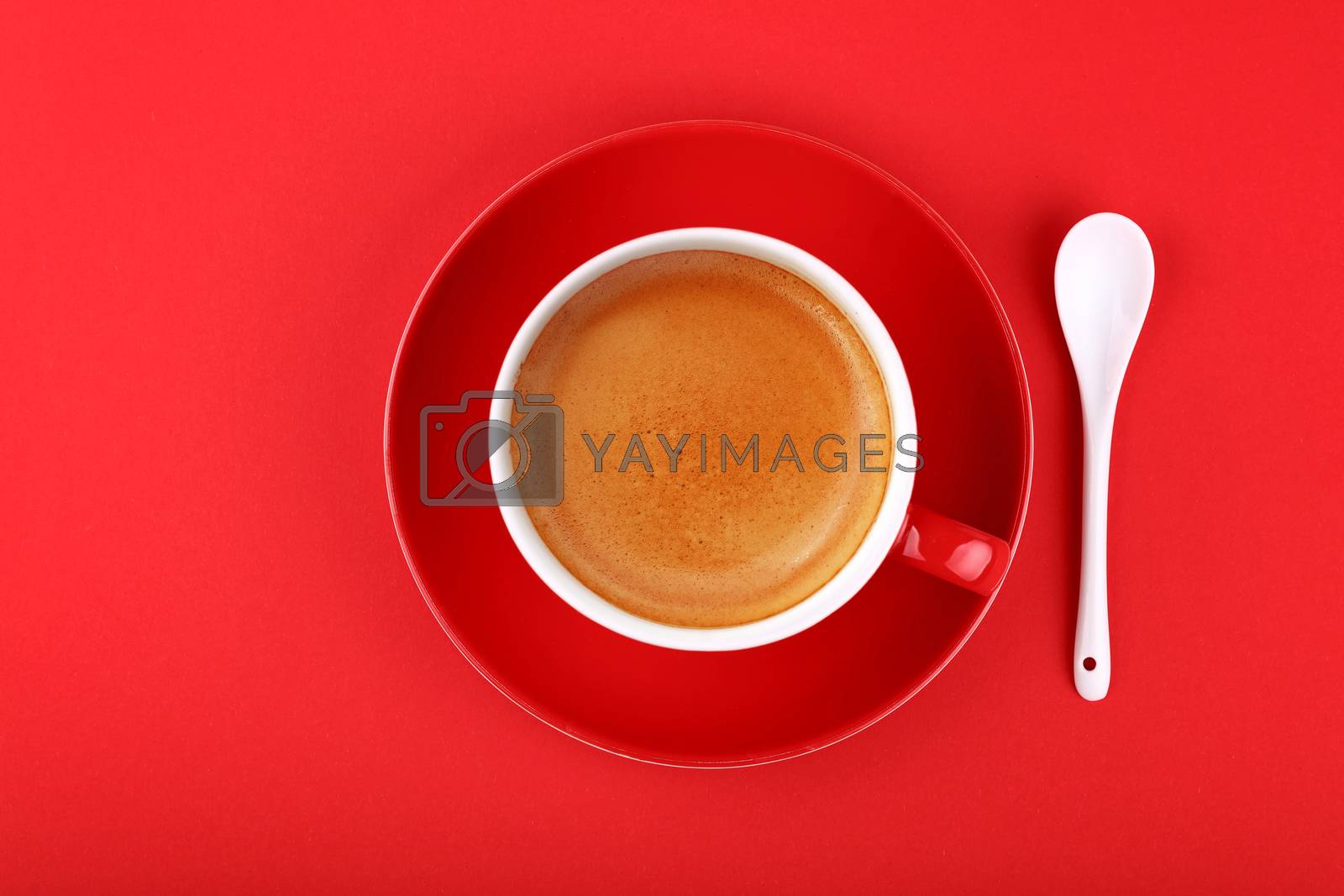 Royalty free image of Full cup of espresso coffee on red paper by BreakingTheWalls