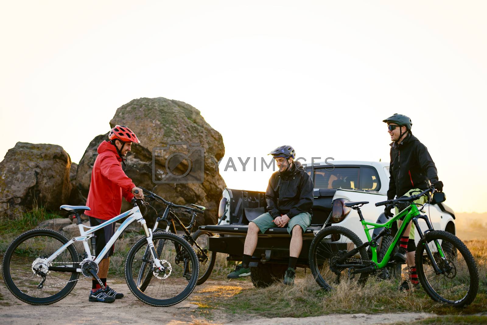 Royalty free image of Friends Resting near Pickup Off Road Truck after Bike Riding in the Mountains at Sunset. Adventure and Travel Concept. by maxpro