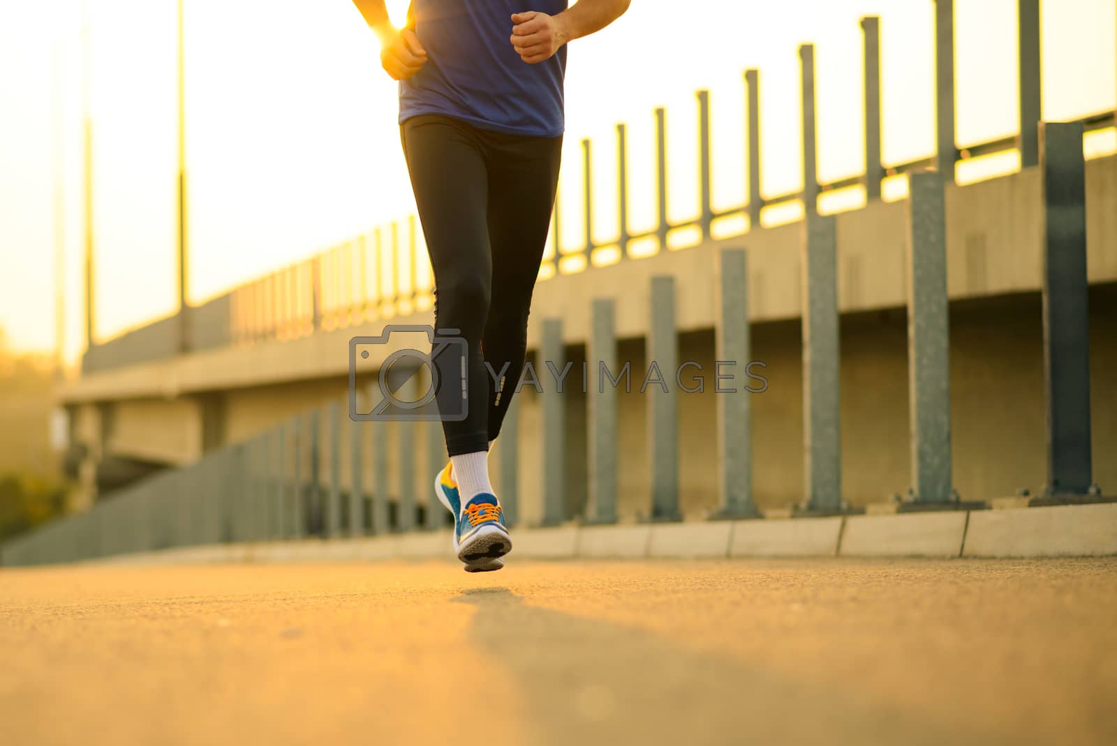 Royalty free image of Close-up of Male Sports Mans Legs Running at Sunset. Healthy Lifestyle and Sport Concept. by maxpro