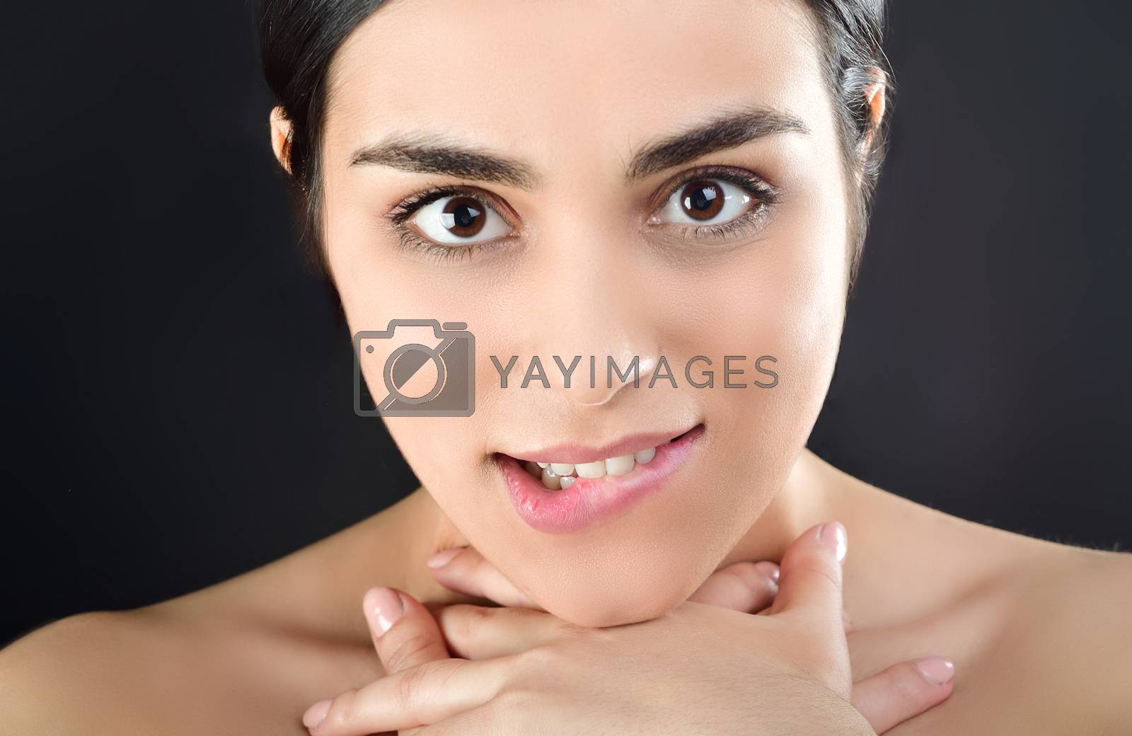 Royalty free image of A young sexy woman passionately looks at the camera, pressing her throat with her hands by xzgorik