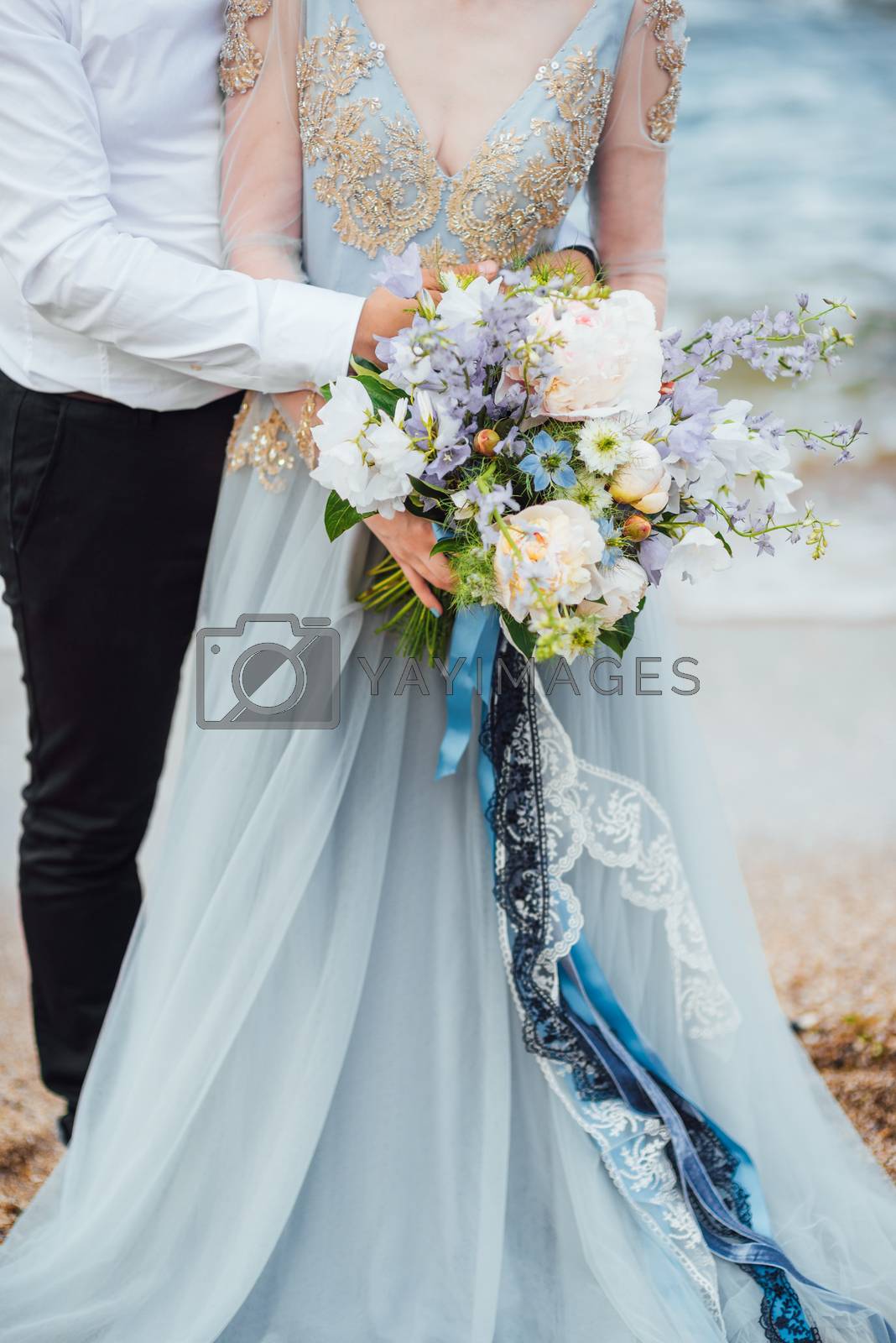 Royalty free image of same couple with a bride in a blue dress walk by Andreua