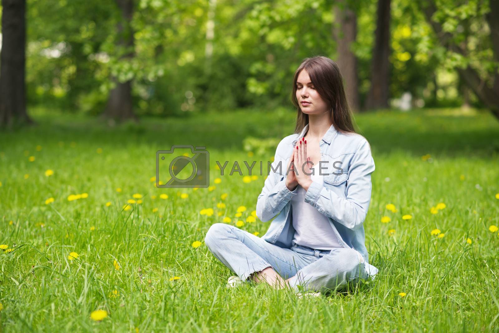 Royalty free image of Young girl meditating in park by ALotOfPeople