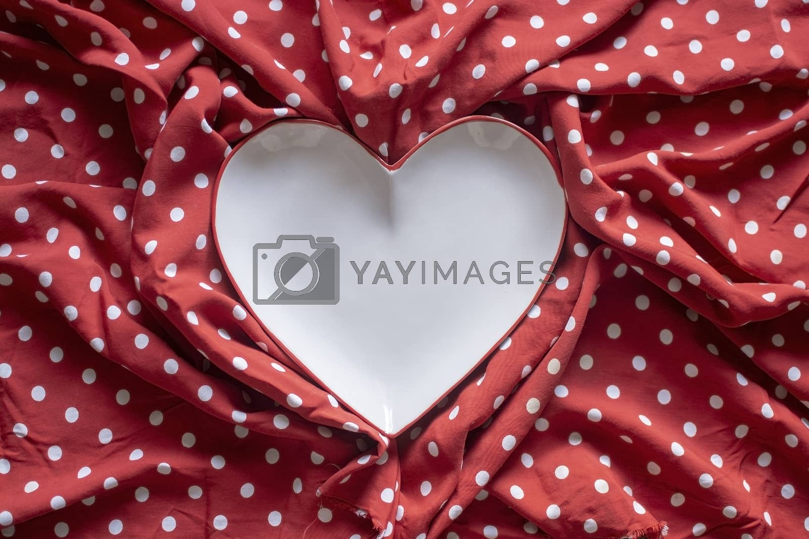 Royalty free image of Stoneware heart plate on red and white polka dot print  by ArtesiaWells