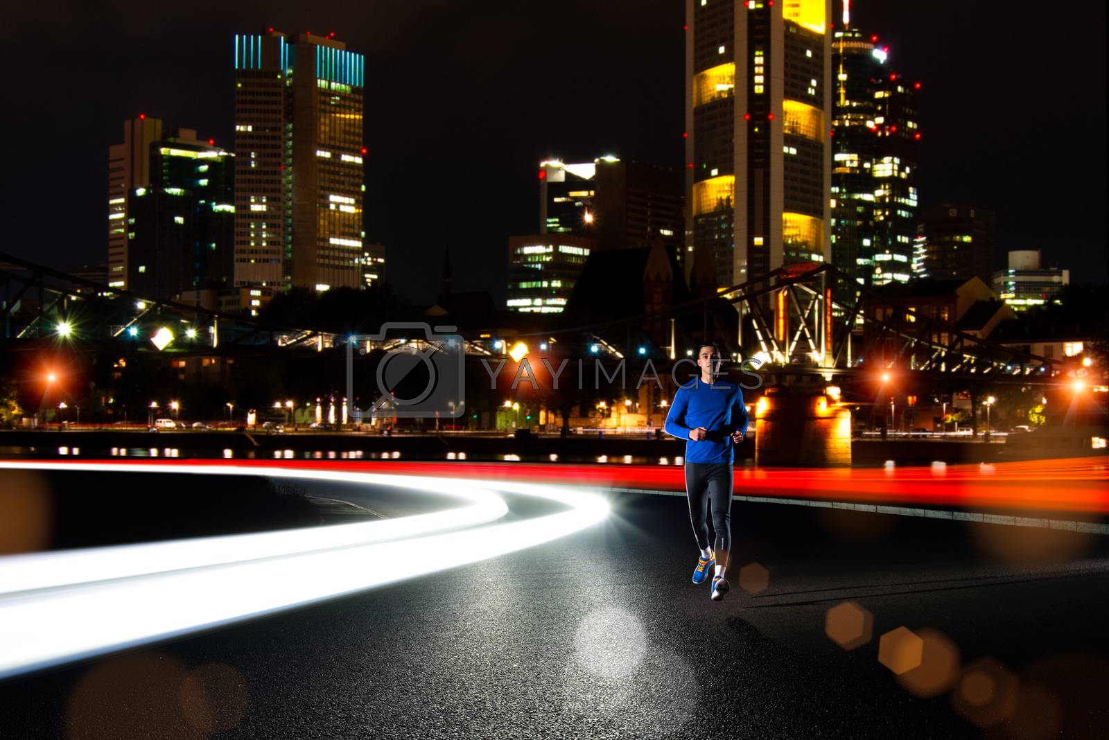 Royalty free image of Young Sports Man Running on the Night Road with Cars Light Trails. Healthy Lifestyle and Urban Sport Concept. by maxpro
