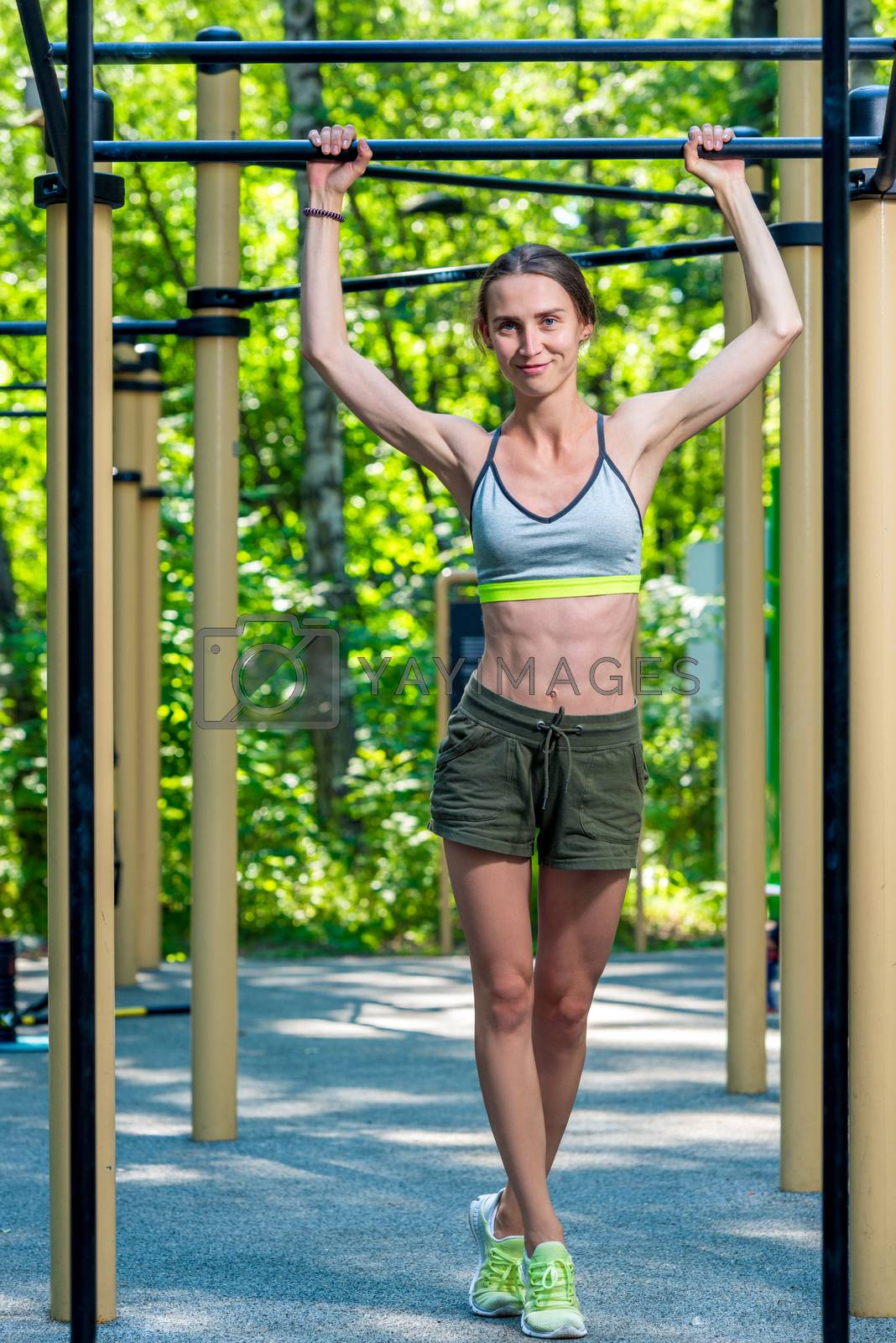 Royalty free image of slender muscular woman posing at the gym in the park during trai by kosmsos111