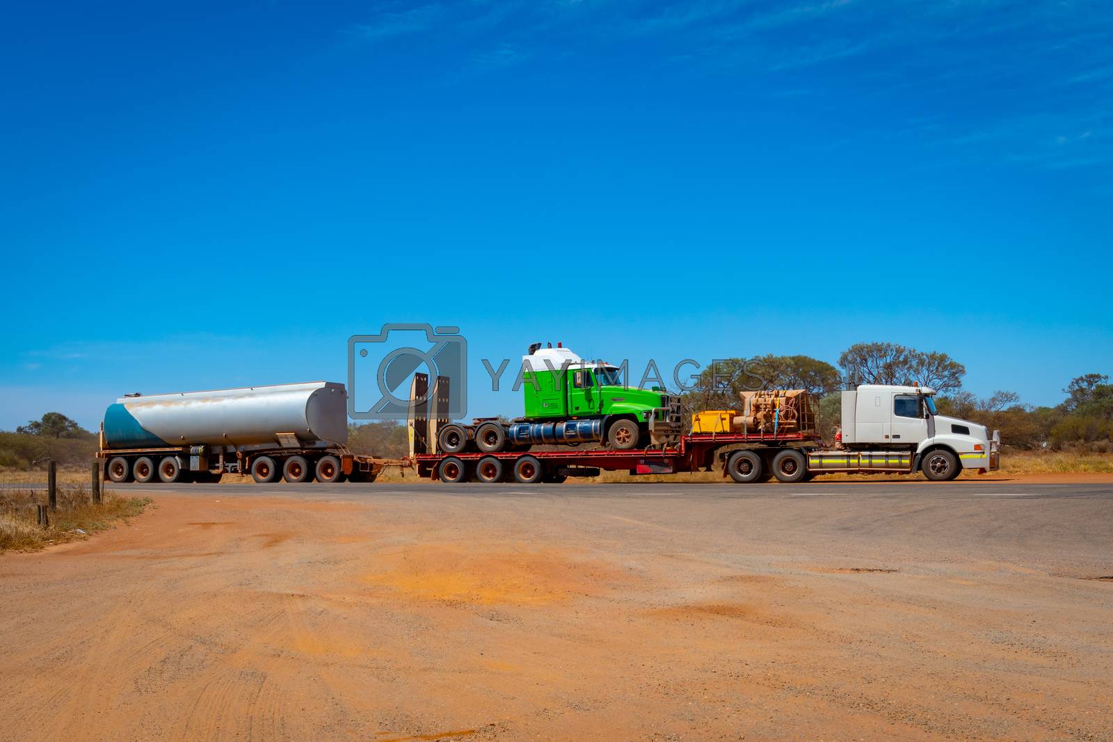 Royalty free image of Road Train in Australia carrying another truck and fuel in the Outback by MXW_Stock