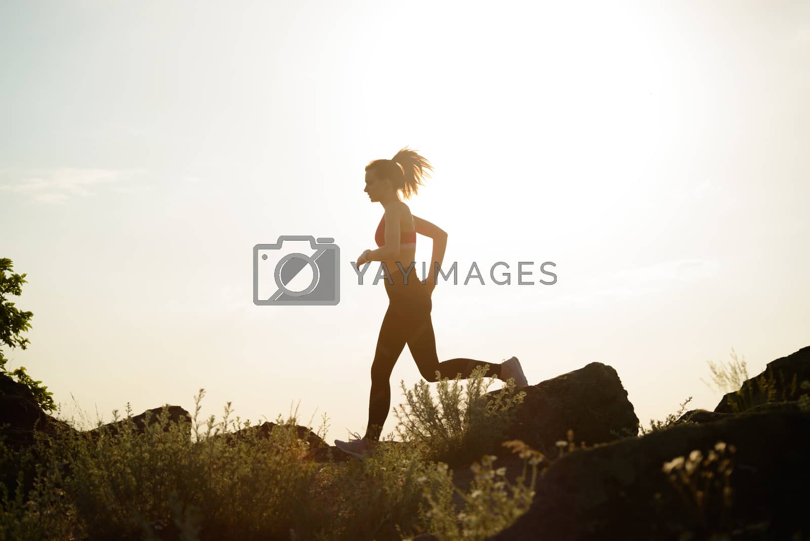Royalty free image of Young Beautiful Woman Running on the Mountain Trail at Hot Summer Sunset. Sport and Active Lifestyle. by maxpro