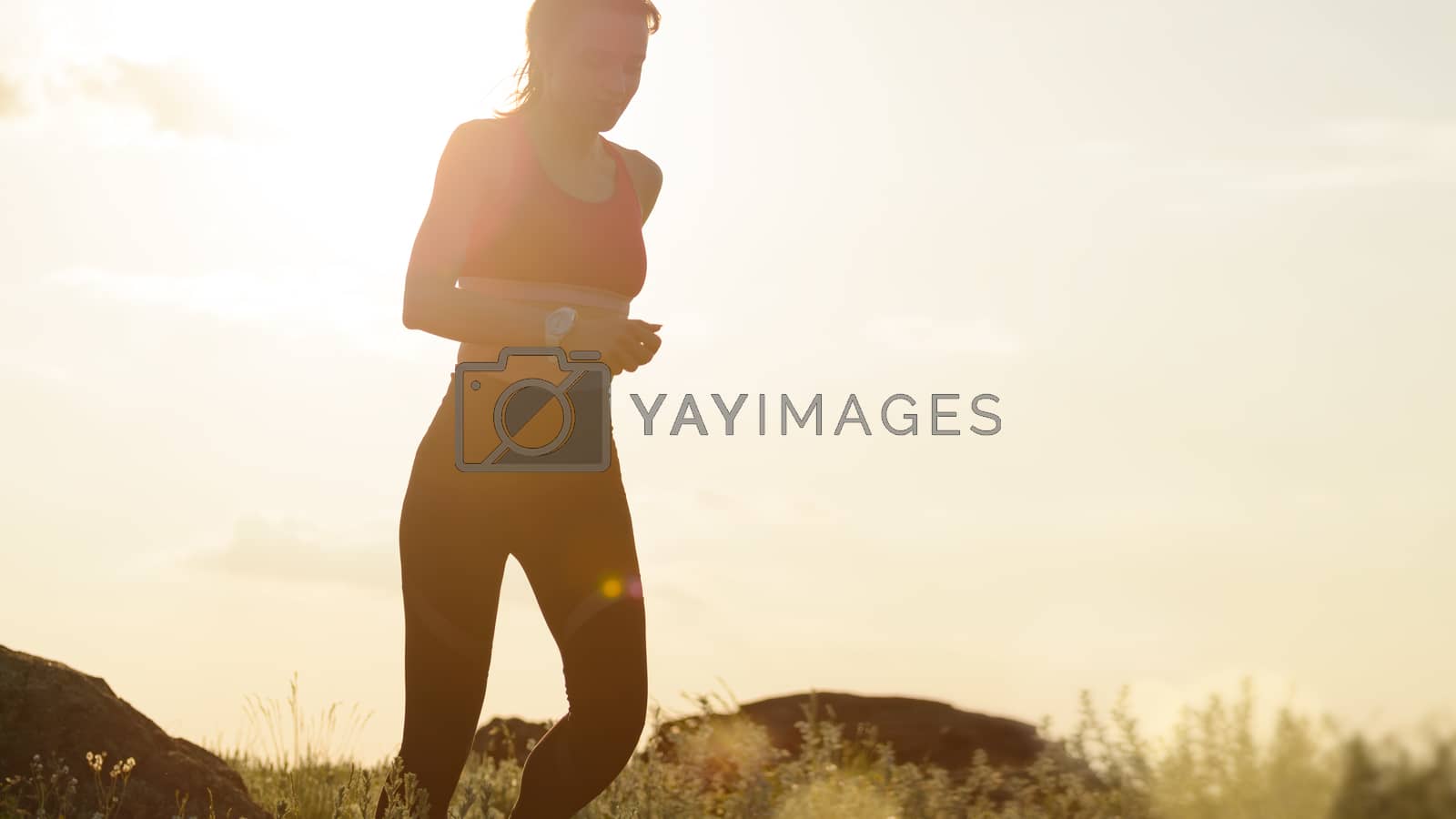 Royalty free image of Young Beautiful Woman Running on the Mountain Trail at Hot Summer Sunset. Sport and Active Lifestyle. by maxpro