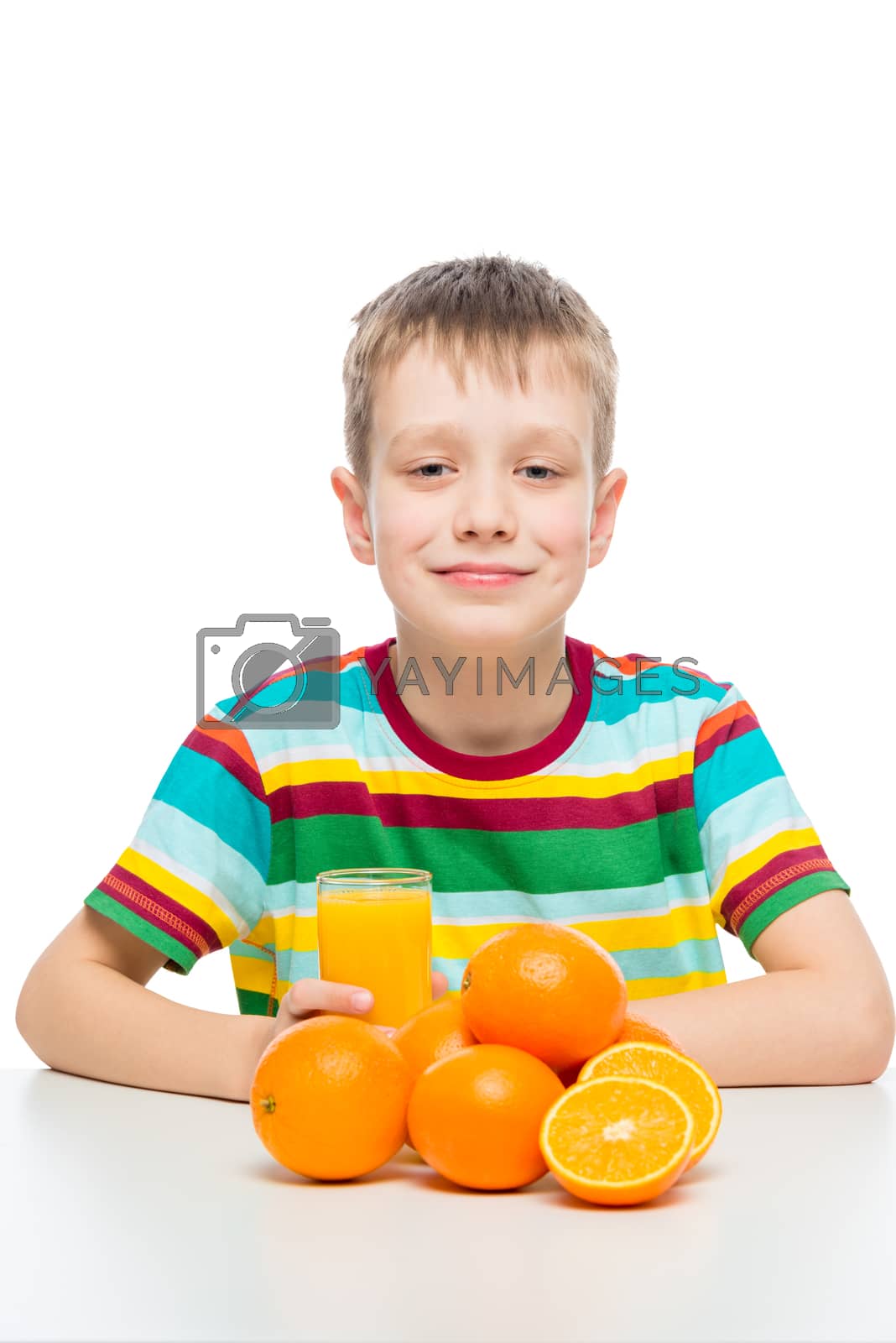 Royalty free image of boy with oranges and a glass of fresh orange juice at the table by kosmsos111