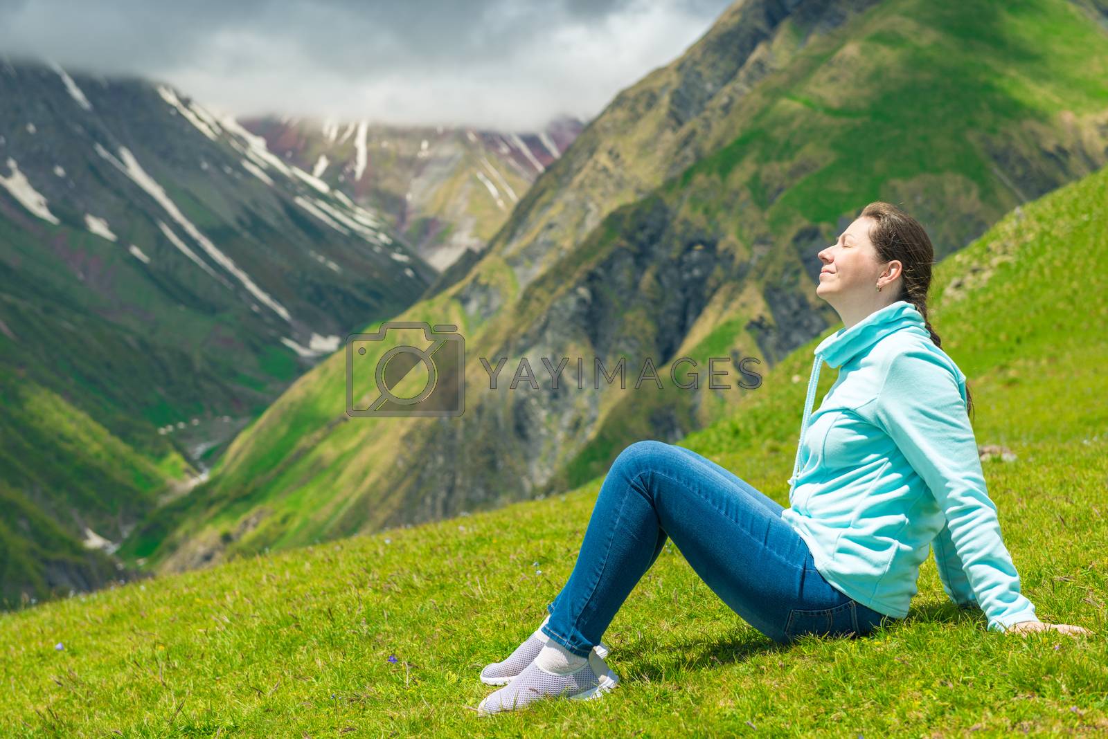 Royalty free image of Happy woman resting and admiring the mountains in the campaign t by kosmsos111