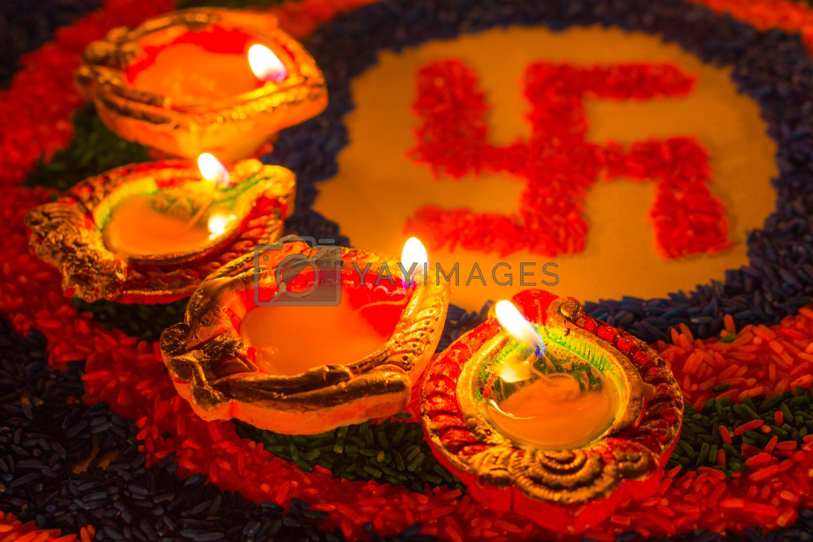 Royalty free image of Indian festival Diwali, Diya oil lamps lit on colorful rangoli w by mikesaran