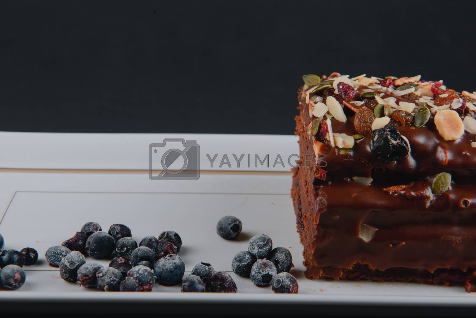 Royalty free image of Chocolate cake with raisins lies on the table by Brejeq