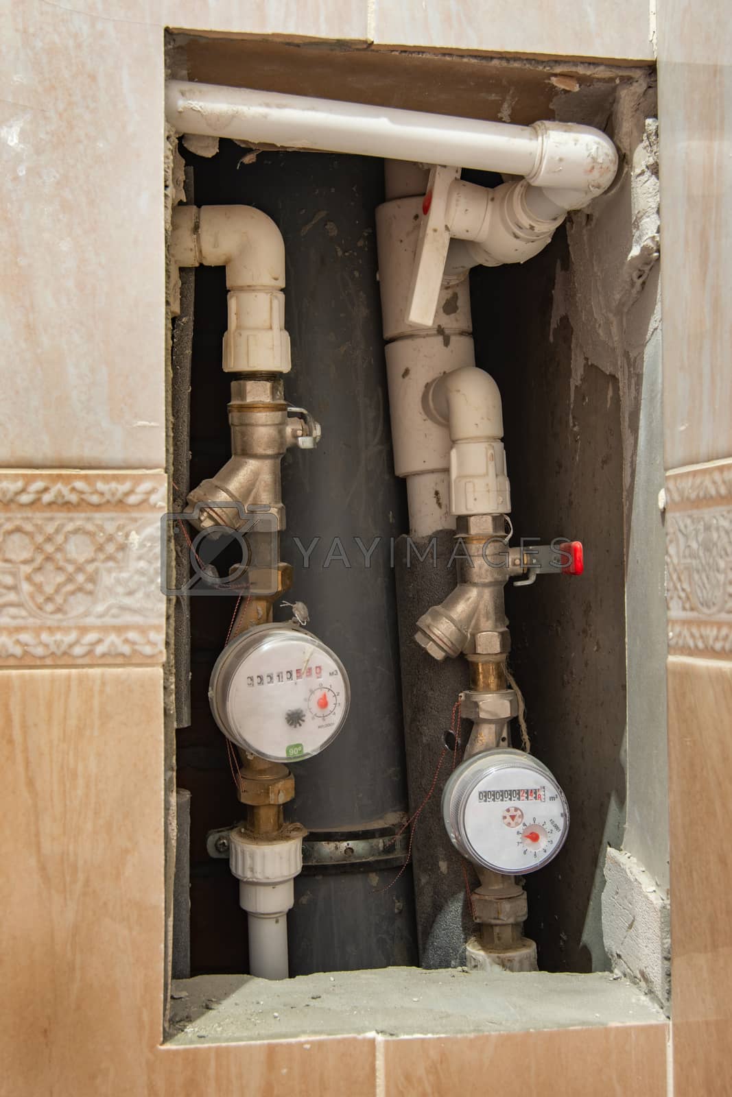 Royalty free image of cold and hot water meters embedded in the wall by Madhourse