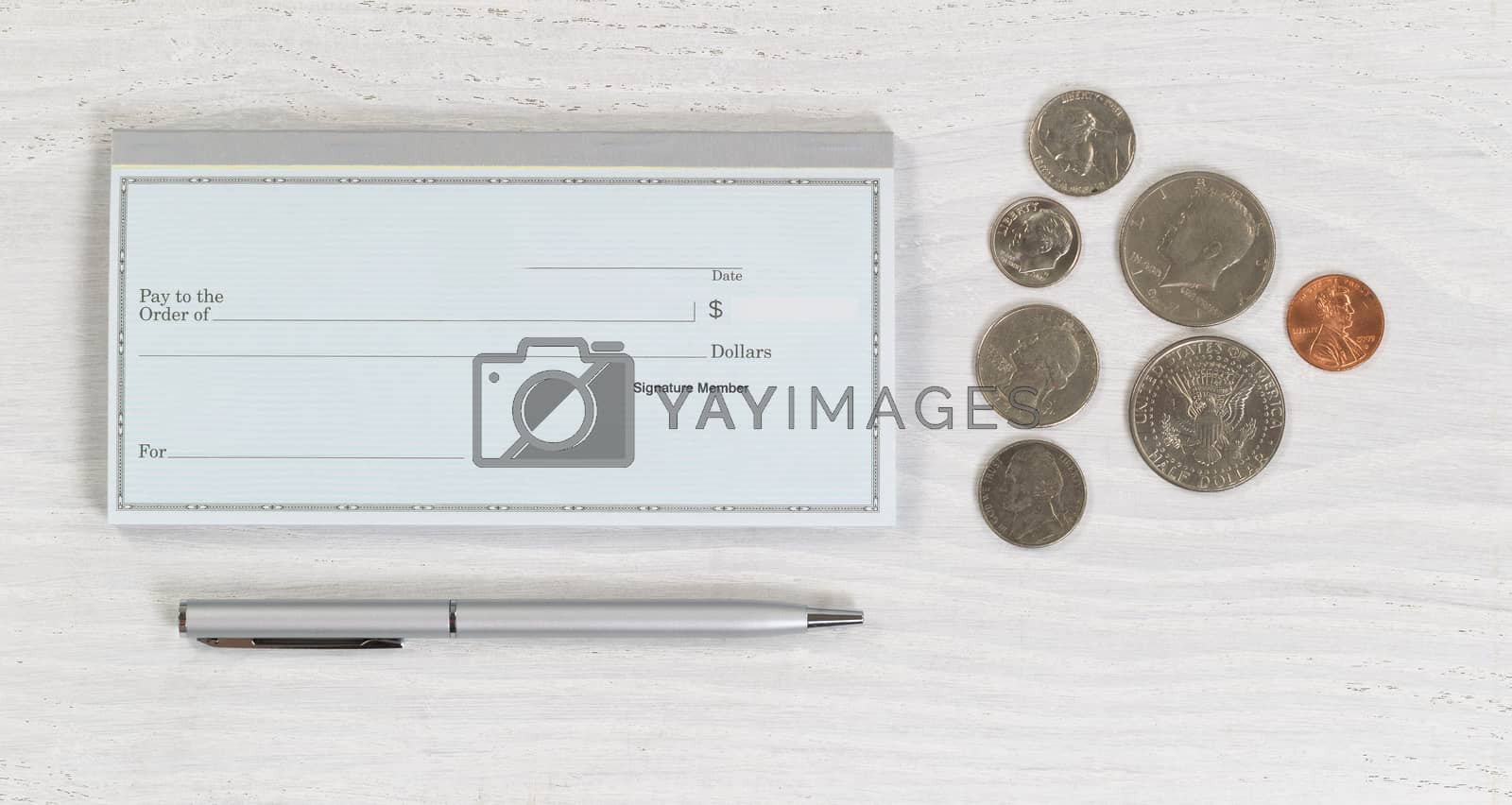 Royalty free image of Blank checkbook with pen and coins on white desktop by tab1962