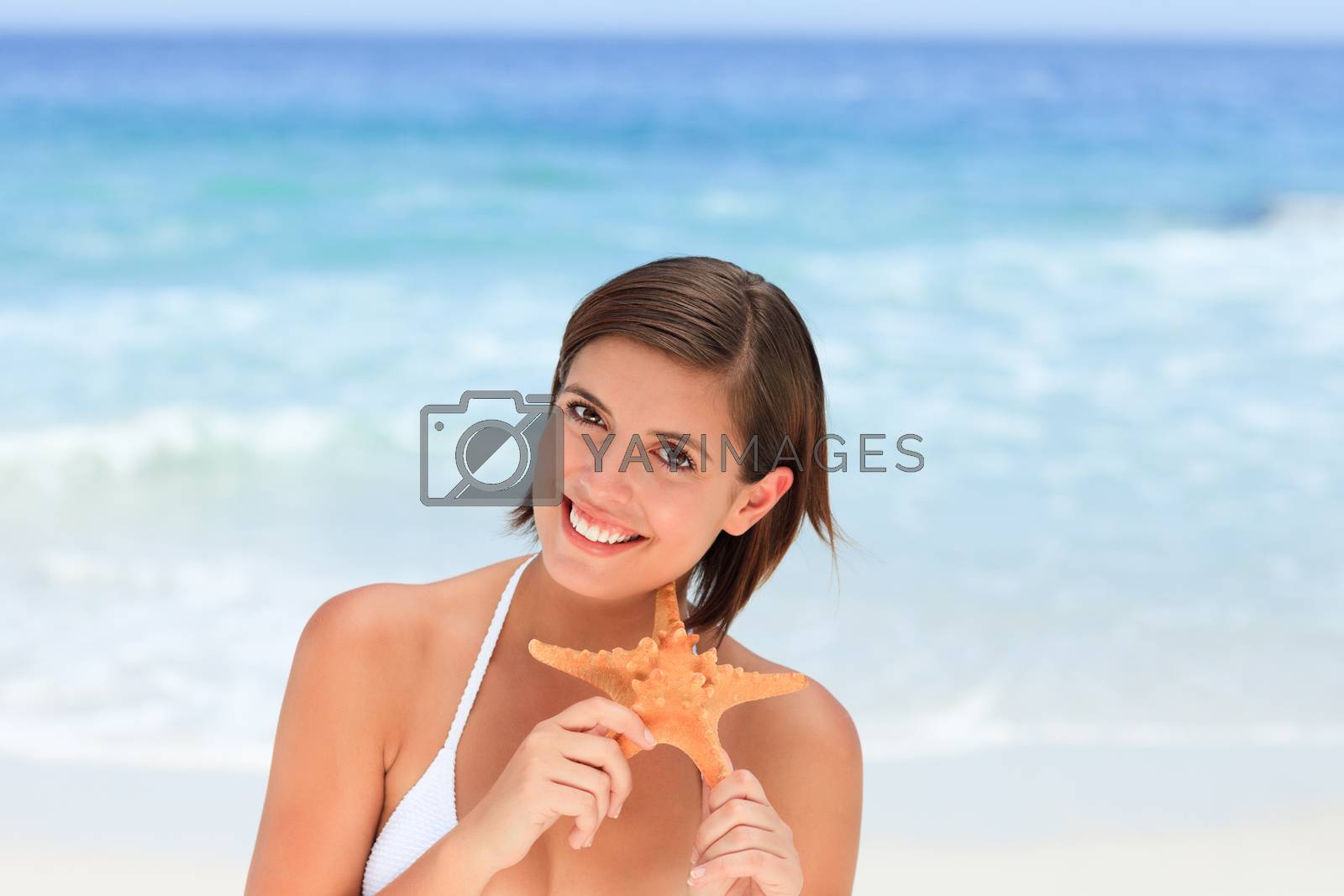 Royalty free image of Lovely woman with a starfish by Wavebreakmedia