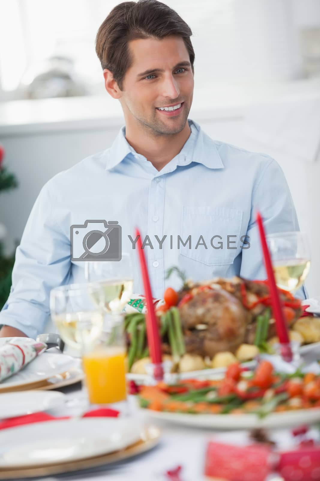 Royalty free image of Attractive man sitting at table for christmas dinner by Wavebreakmedia