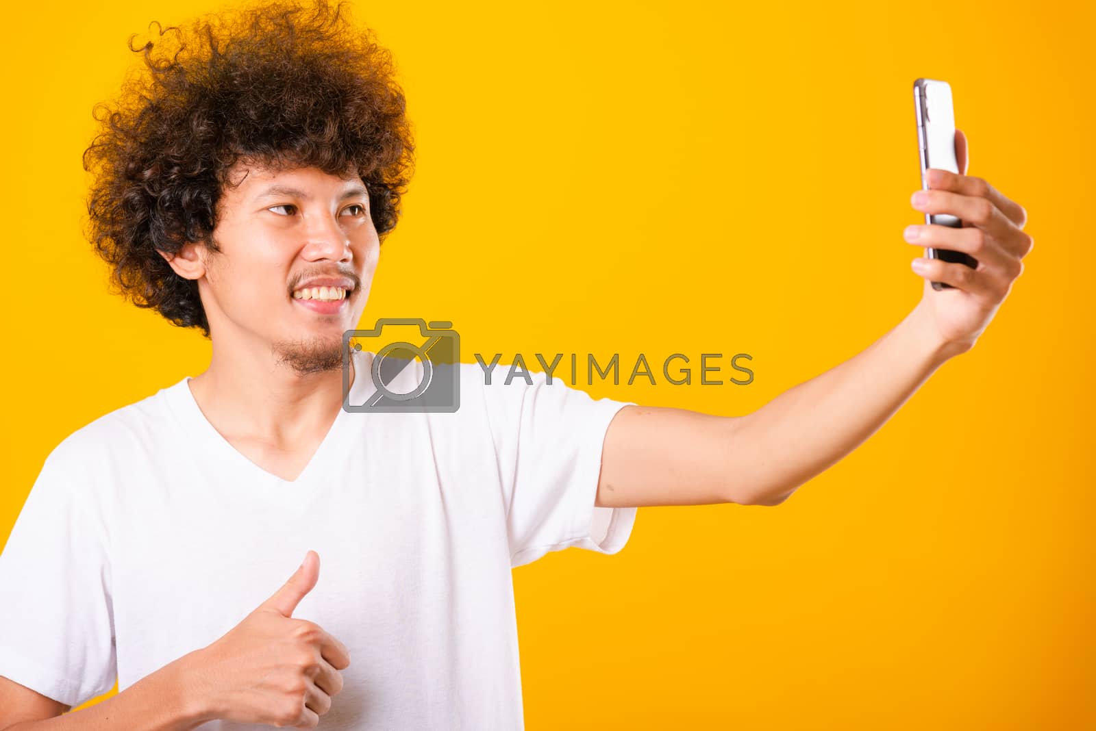 Royalty free image of Portrait asian handsome man curly hair taking selfie with mobile by Sorapop