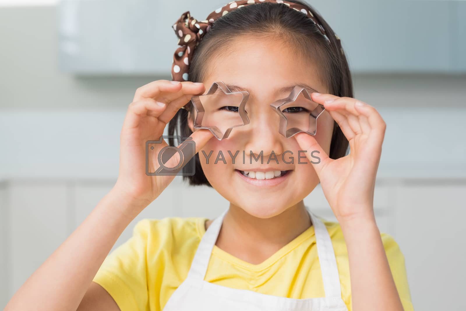 Royalty free image of Closeup portrait of a smiling young girl holding cookie molds by Wavebreakmedia