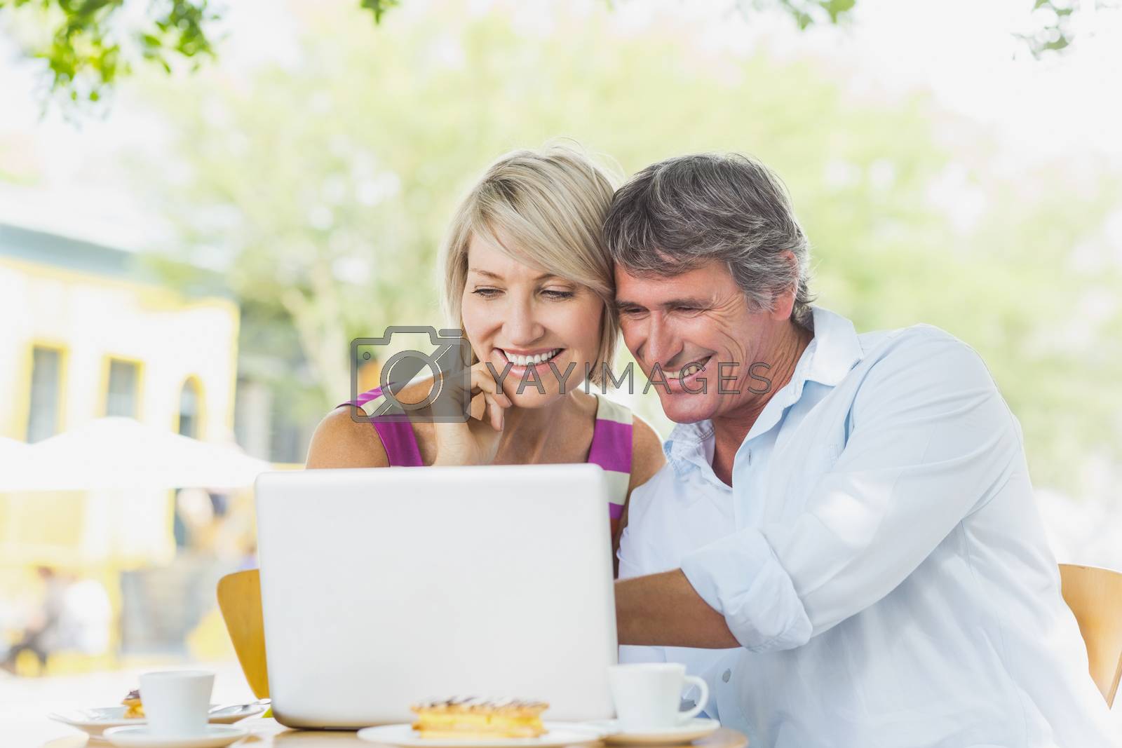 Royalty free image of Couple using laptop at cafe by Wavebreakmedia