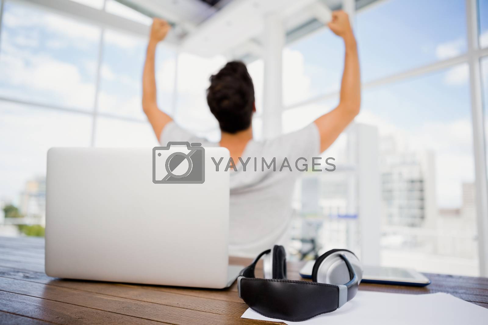 Royalty free image of Man cheering at his desk by Wavebreakmedia