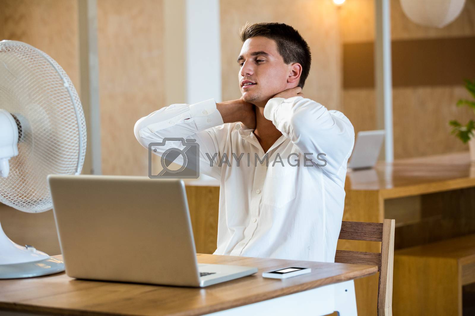 Royalty free image of Man enjoying a breeze while using laptop by Wavebreakmedia