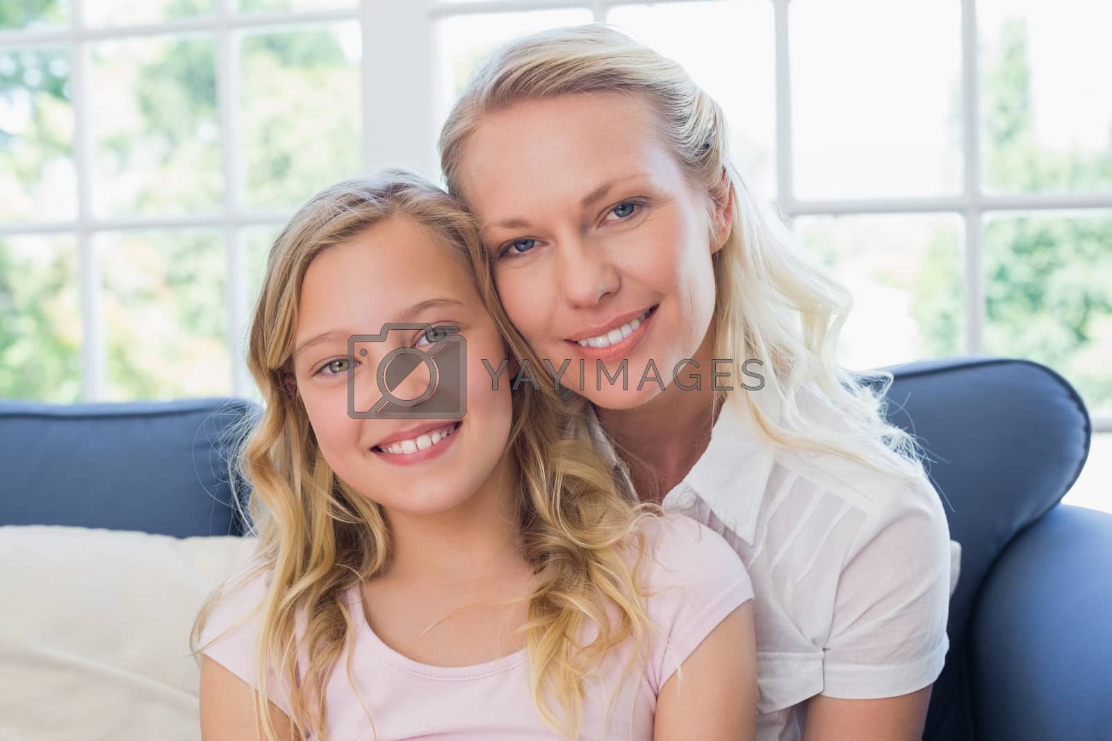 Royalty free image of Happy mother and daughter sitting on sofa by Wavebreakmedia