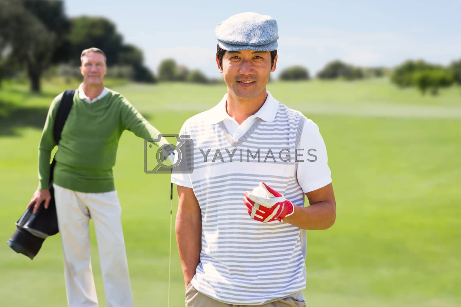 Royalty free image of Composite image of golfing friends smiling at camera  by Wavebreakmedia