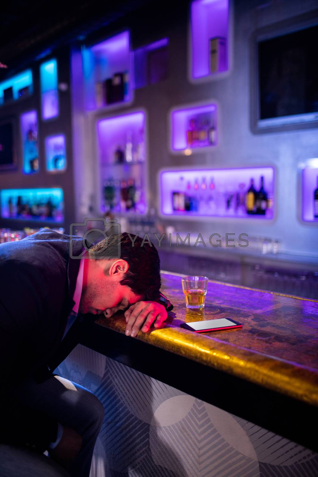 Royalty free image of Depressed man having whisky at bar counter by Wavebreakmedia