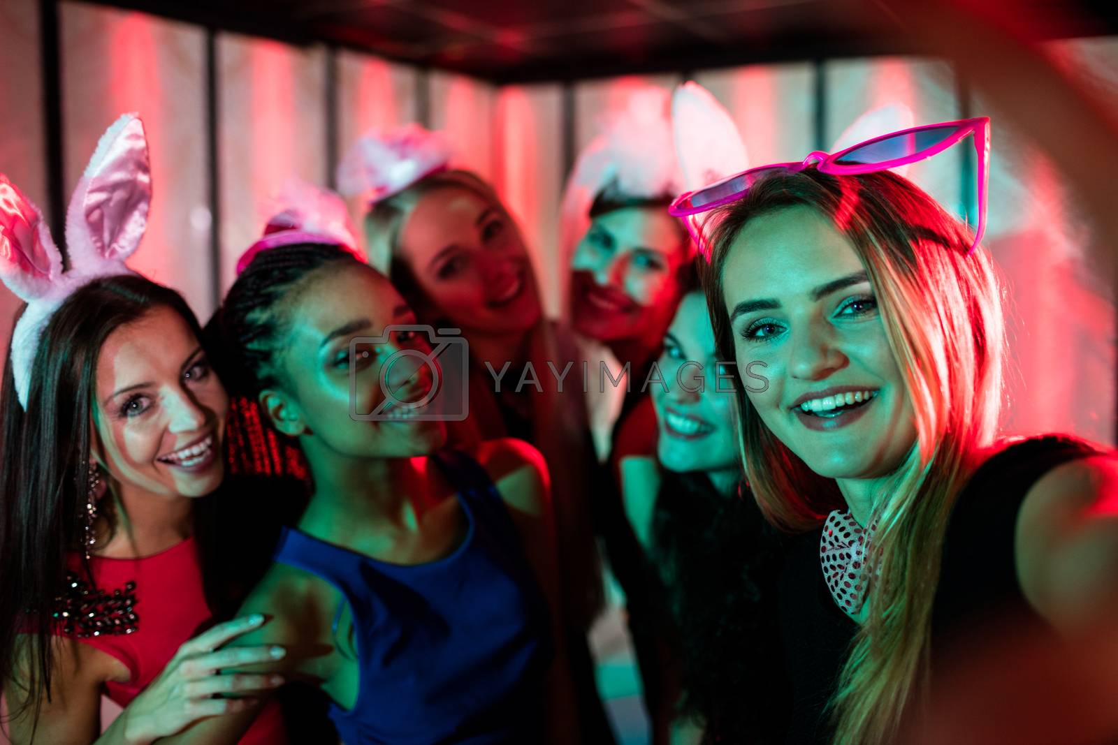 Royalty free image of Group of smiling friends posing for a selfie by Wavebreakmedia