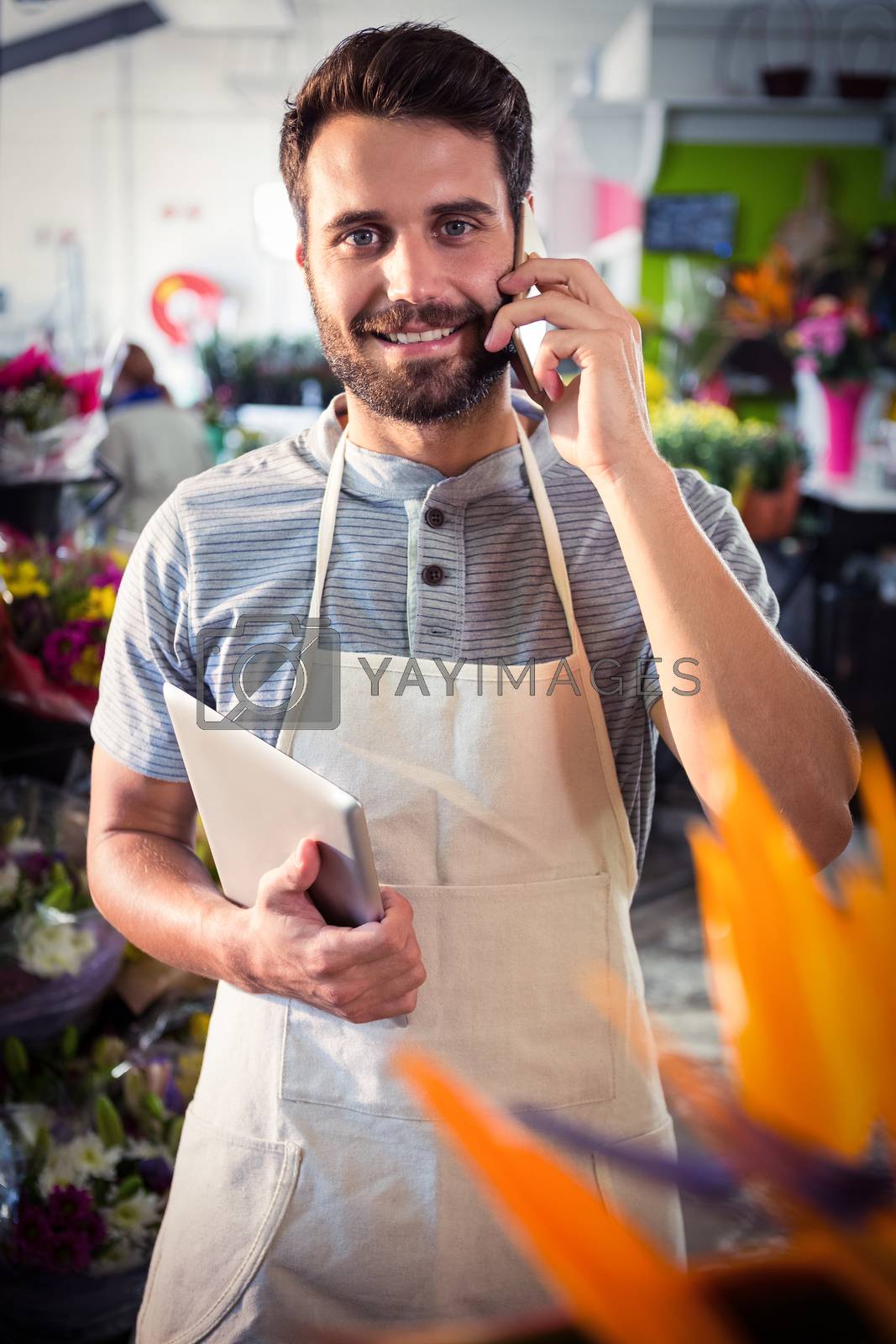 Royalty free image of Male florist talking on mobile phone by Wavebreakmedia