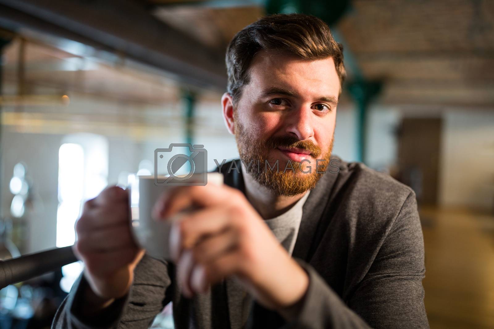 Royalty free image of Man holding coffee cup by Wavebreakmedia