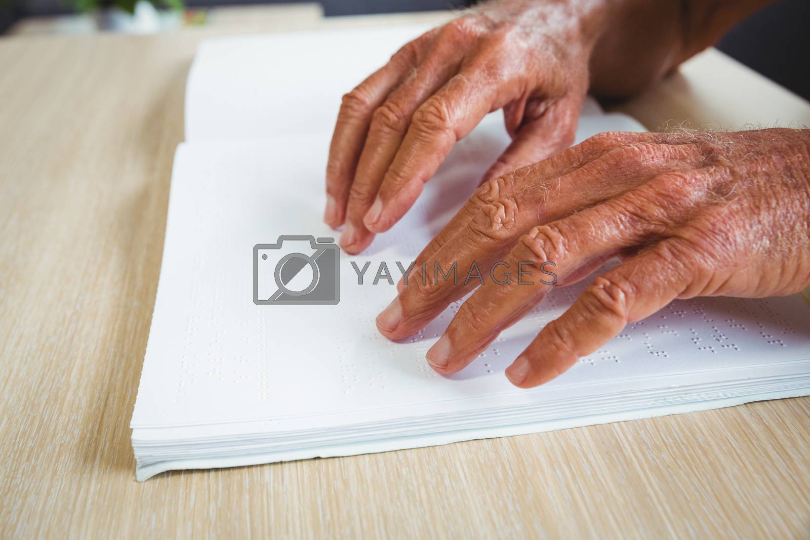 Royalty free image of Senior man using braille to read by Wavebreakmedia