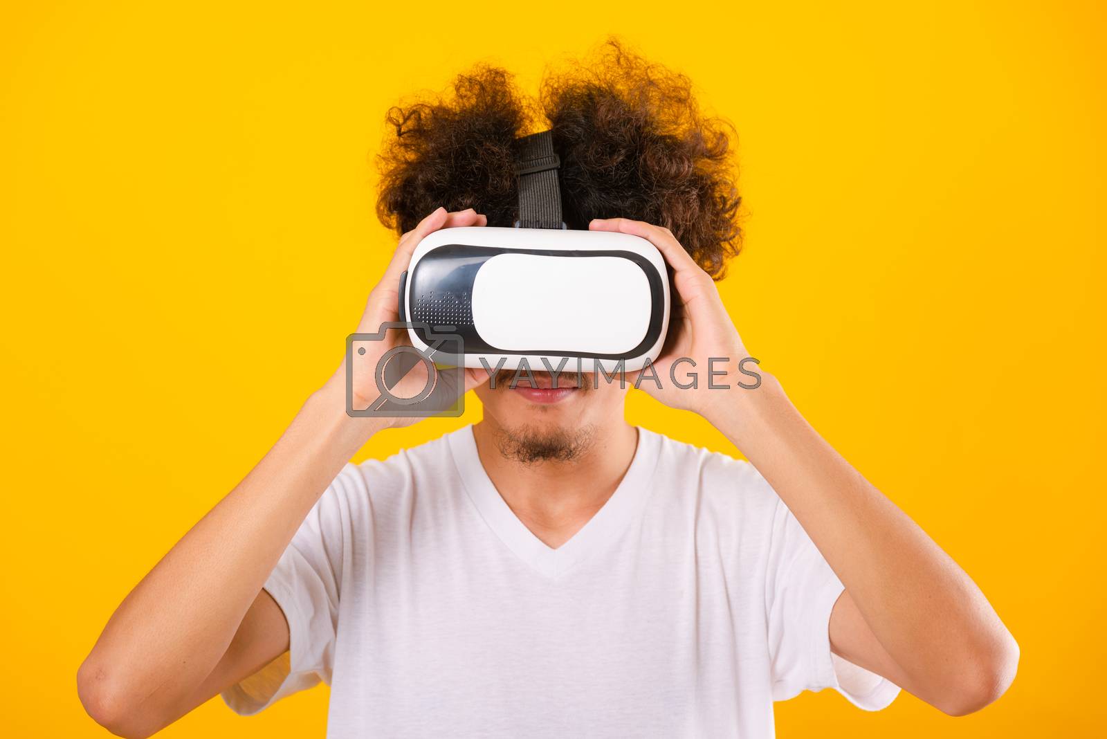 Royalty free image of Asian handsome man with curly hair he using virtual reality head by Sorapop